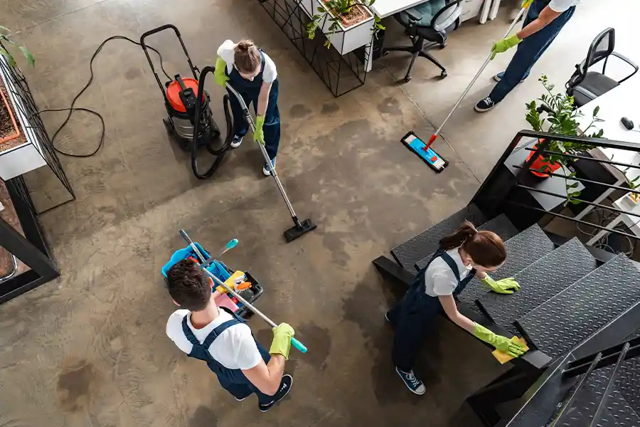 How much does commercial cleaning cost? Top-down view of a professional cleaning team meticulously working in a contemporary office space.